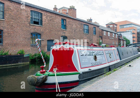 Bunte Narrowboat auf dem Kanal läuft durch Birmingham am Brindley Place Stockfoto