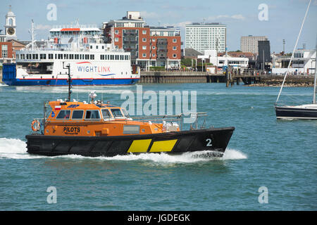 Orange und schwarz Associated British Ports pilot Boot in Aktion in Portsmouth Harbour. Nautische Szene mit den IOW Fähren oder Gunwharf im Hintergrund Stockfoto