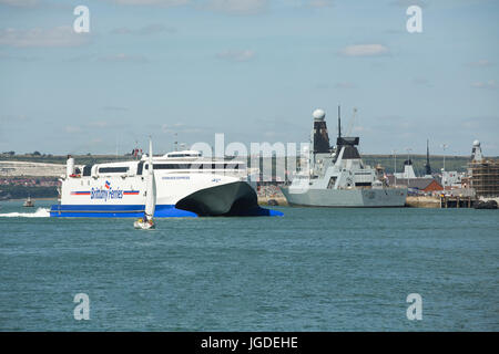 Brittany Ferries Katamaran Normandie Express vorbei HMS Daring auf seinem Weg aus Portsmouth Harbour. Stockfoto