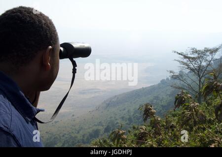 Man sieht über Kraterrand mit Fernglas, Ngorongoro Crater, Tansania Stockfoto
