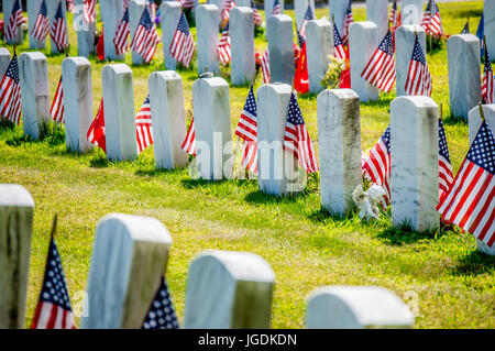 Reihen von Grabsteinen mit amerikanischen Flaggen auf Soldatenfriedhof Stockfoto