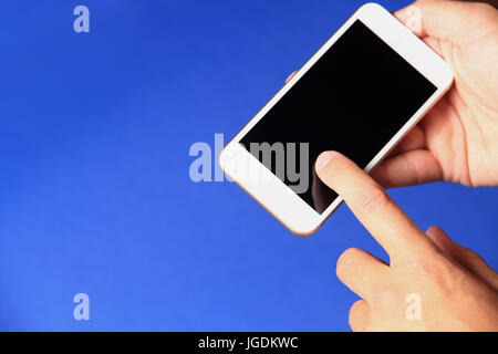 Neues Smartphone in der Hand auf blauem Hintergrund. Handy mit schwarzer Bildschirm-Nahaufnahme. Stockfoto