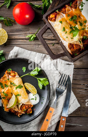 Mexikanisches Essen. Küche von Südamerika. Traditionelles Gericht der würzige Rindfleisch Enchiladas mit Mais, Bohnen, Tomaten. Auf ein Backblech, auf alten rustikalen hölzernen bac Stockfoto