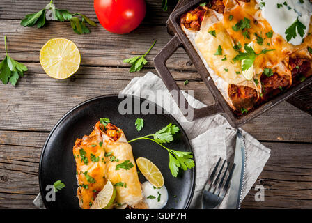 Mexikanisches Essen. Küche von Südamerika. Traditionelles Gericht der würzige Rindfleisch Enchiladas mit Mais, Bohnen, Tomaten. Auf ein Backblech, auf alten rustikalen hölzernen bac Stockfoto