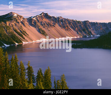 USA, Oregon, Crater Lake Nationalpark, Sonnenaufgang am Westrand des Crater Lake mit The Watchman (links) und Hillman Peak (Mitte) über Wizard Island. Stockfoto