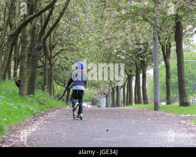 junge Teenager Student Kind auf einem Roller ein Leben Weg hinunter Stockfoto