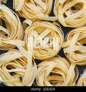 Draufsicht auf ungekochte Nester Tagliatelle Nudeln Stockfoto