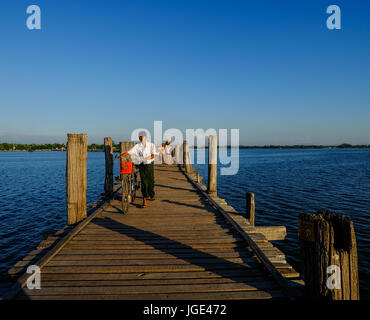 Mandalay, Myanmar - 18. Oktober 2015. Ein Mann mit Fahrrad auf Ubein Brücke in Mandalay, Myanmar. Die Brücke ist vermutlich die älteste und längste teakwoo Stockfoto