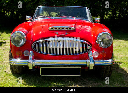 Vorderansicht eines leuchtend roten Sportwagens Austin Healey auf einer Oldtimer-Show in Wales, Großbritannien Stockfoto