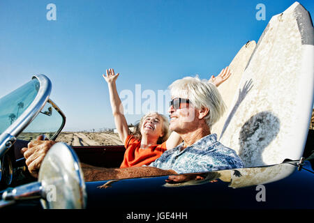 Älteres Ehepaar der kaukasischen im Cabrio mit Surfbrettern am Strand Stockfoto
