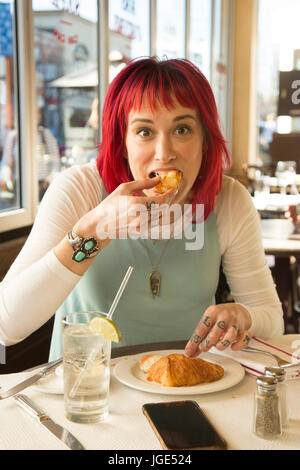 Kaukasische Frau Croissant im Restaurant Essen Stockfoto