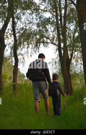 Vater und Sohn zu Fuß in den Wald bei Sonnenuntergang Stockfoto