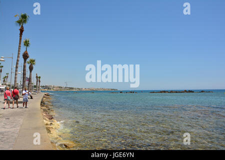 Menschen zu Fuß entlang Paphos Harbouside im Sonnenschein Stockfoto