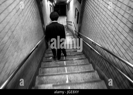 Japanischer Geschäftsmann im Anzug zu Fuß hinunter Treppe am Bahnhof Higashi-Ginza, Tokio, Japan Stockfoto