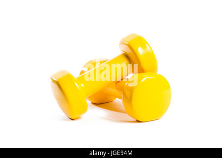 Zwei gelbe Kurzhanteln auf einem isolierten Hintergrund in eine zufällige Reihenfolge Stockfoto
