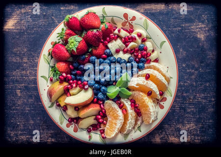 Eine Nahaufnahme von einer Platte mit gemischten Früchten wie Erdbeeren, Orangen, Blaubeeren, Äpfel und Bananen Stockfoto