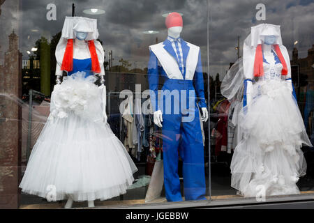 Drei Shop Mannequins in rot, weiß und blau farbige Kleidung gekleidet stehen im Fenster des recycling Kleidung Nächstenliebe Traider, im 4. Juli 2017, in Brixton, London, England. Stockfoto