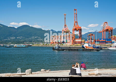 Laden Kräne im Hafen von Vancouver, als von den Ufern der Krabbe Park gesehen. Burrard Inlet und die North Shore Berge. Vancouver BC Kanada Stockfoto