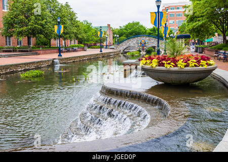 Friedrich, USA - 24. Mai 2017: Carroll Creek in Maryland Stadtpark mit Kanal, Brücke und Brunnen Wasserfall und Blumen im Sommer Stockfoto