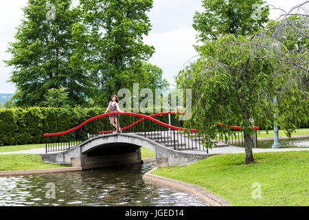 Harrisburg, USA - 24. Mai 2017: Italienisch Lake Park in Pennsylvania Hauptstadt mit jungen Frau auf rote Brücke Stockfoto