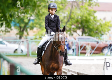 Junge Teenager-Mädchen in Helm Reitpferd für Dressurreitturnier Stockfoto