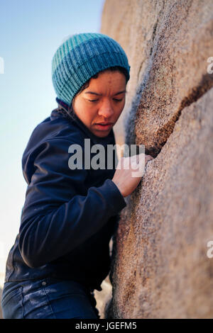 Junge Mischlinge Frau gekleidet in kaltem Wetter Kleidung Felsen klettert in der Wüste Stockfoto