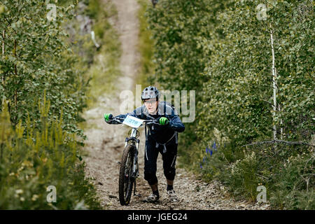Mann-Radfahrer mit Sport Fahrrad bergauf bei regionalen Wettkämpfen auf Mountainbike Stockfoto
