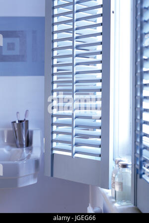 Fensterläden auf Fenster in blauen und weißen Badezimmer Stockfoto