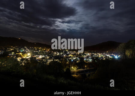 Einer Kleinstadt liegt in einem Tal in der Nacht. Stockfoto