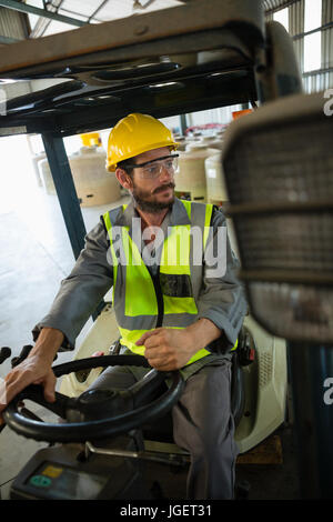Arbeiter, die Gabelstapler Autofahren in Fabrik Stockfoto