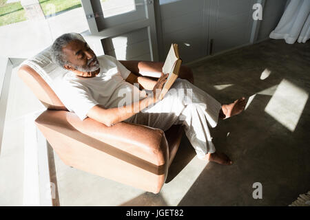 Aktive senior Mann liest ein Buch zu Hause Stockfoto
