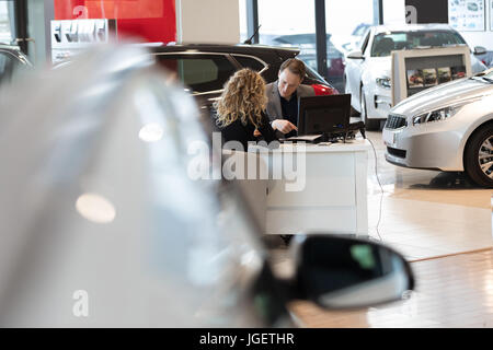 Verkäufer Diskussion mit Kunden im Autohaus Stockfoto