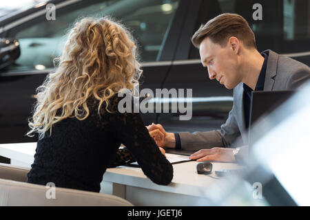Auto Verkäufer im Gespräch mit Kunden im Schauraum Stockfoto