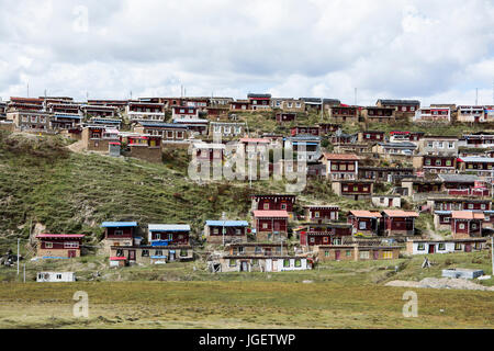 Buntes Dorf auf dem Hügel, im Grasland des Tagong, Sichuan, China. Stockfoto