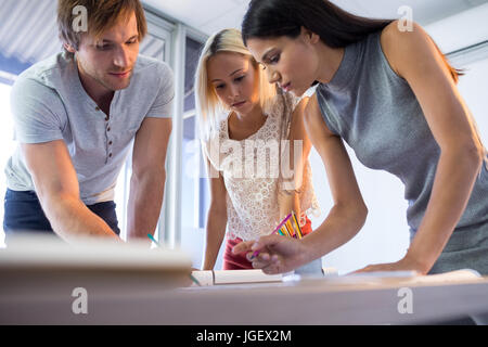 Architekten, die auf Blaupause an ihrem Schreibtisch im Büro Stockfoto