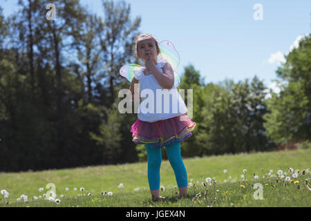 Nachdenklich Mädchen stehen auf dem Rasen im Park an einem sonnigen Tag Stockfoto