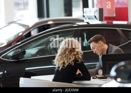 Auto Verkäufer Diskussion mit Kunden im Schauraum Stockfoto