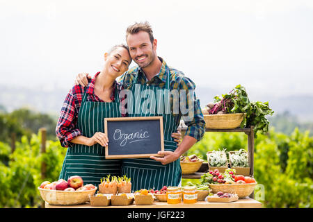 Porträt des jungen Paares Holding Tafel mit Text auf der farm Stockfoto