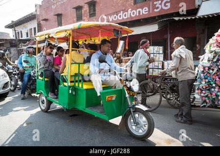 Grüne und gelbe Dreirad Taxi Köpfe eine belebten Straße in Indien Stockfoto