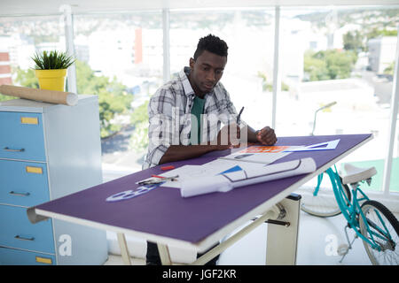 Männliche Exekutive über Reißbrett im Büro arbeiten Stockfoto