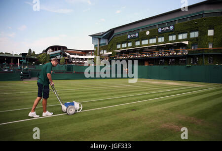 Bodenpersonal bereiten die äußeren Gerichte am Tag vier der Wimbledon Championships in The All England Lawn Tennis and Croquet Club, Wimbledon. Stockfoto