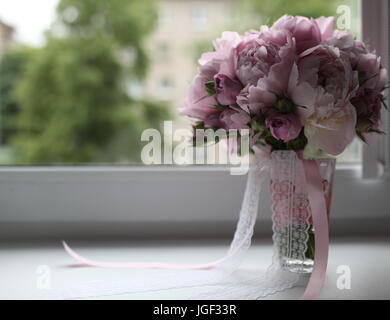 Blumenstrauß mit Band auf der Fensterbank Stockfoto