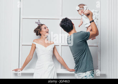 Glückliche Familie auf einem weißen Hintergrund in weißen Kleidern Stockfoto
