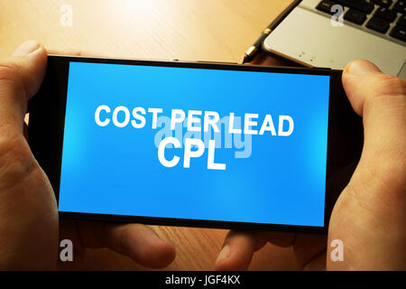 Hand mit Smartphone mit Worten Kosten pro Lead kpl. Stockfoto