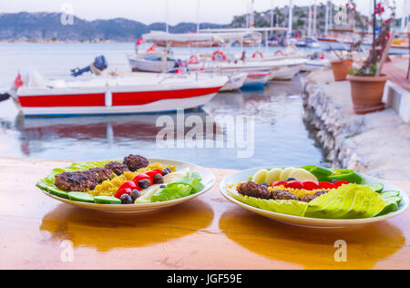 Das Outdoor-Hafen-Café bietet leckere türkische Gericht Kofta mit Blick auf festgemachten Boote, Kekova, Türkei Stockfoto