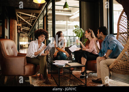 Team junge Berufstätige mit Diskussion in Büro. Führungskräfte treffen im Büro Lobby für neues Projekt. Stockfoto