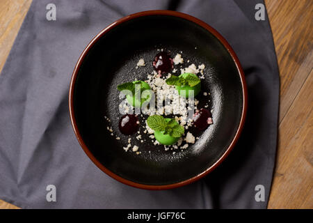 Leckeres Restaurant Dessert aus Äpfeln, Schokolade, Minze und Karamel glasiert in Form von kleinen Äpfel mit Blättern. Draufsicht oder flach legen Stockfoto