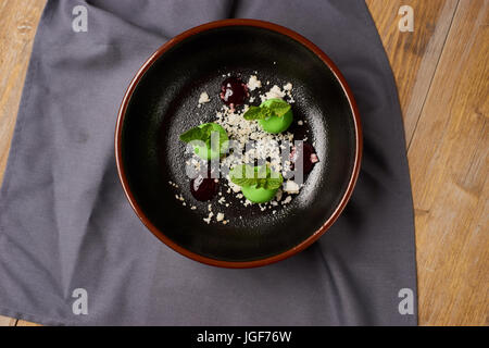 Leckeres Restaurant Dessert aus Äpfeln, Schokolade, Minze und Karamel glasiert in Form von kleinen Äpfel mit Blättern. Draufsicht oder flach legen Stockfoto