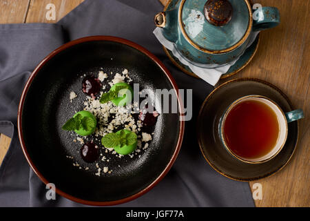 Leckeres Restaurant Dessert aus Äpfeln, Schokolade, Minze und Karamel glasiert in Form von kleinen Äpfel mit Blättern. Draufsicht oder flach legen Stockfoto