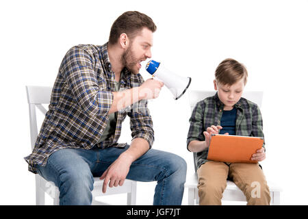 Vater mit Megaphon schreien an Sohn mit digital-Tablette, Familienprobleme Konzept Stockfoto